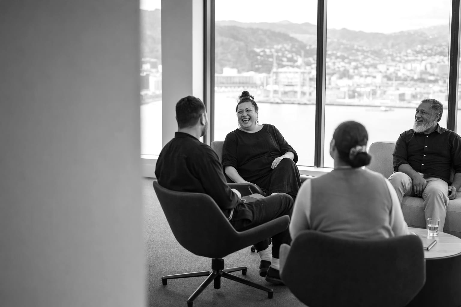 A small team in conversation around a table in a Wellington office