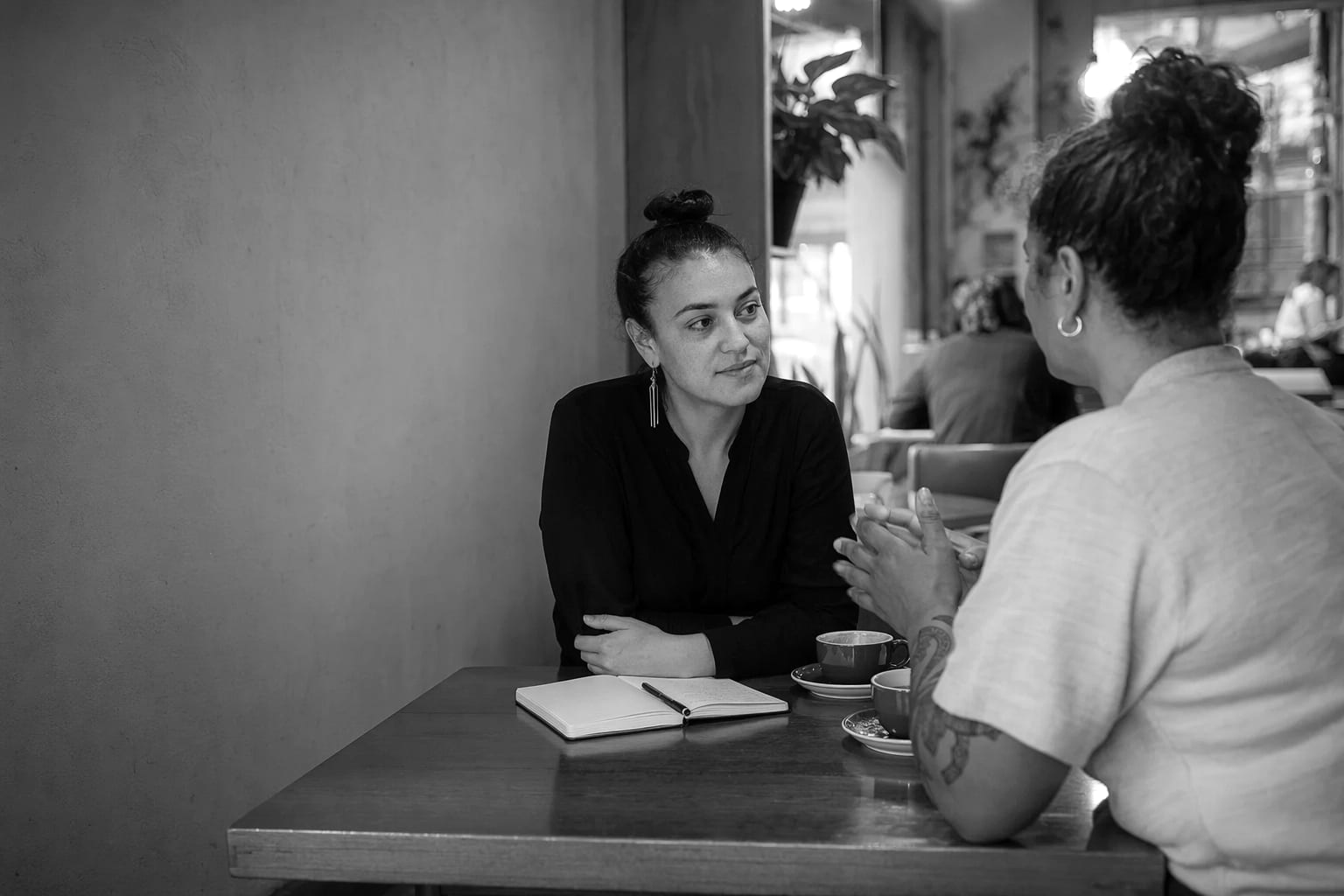Two people meeting over coffee at a café table in Wellington