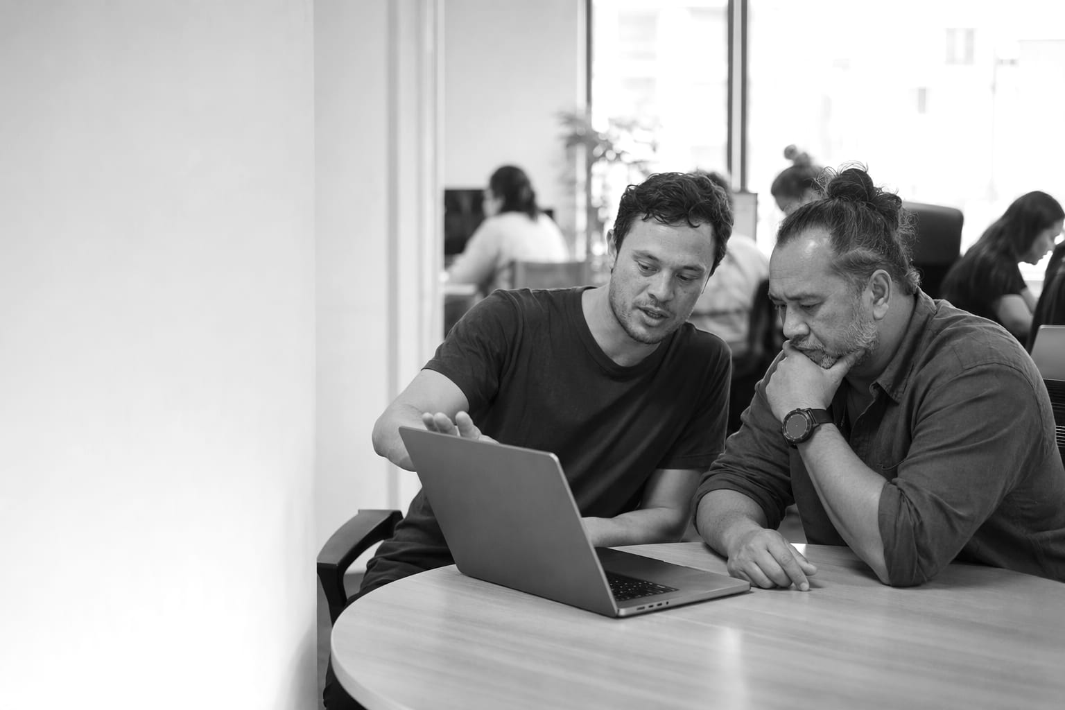 A founder and an engineer reviewing an application together on a laptop